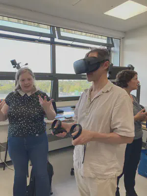A visitor trying a virtual-reality headset and hand controllers at the lab inauguration
